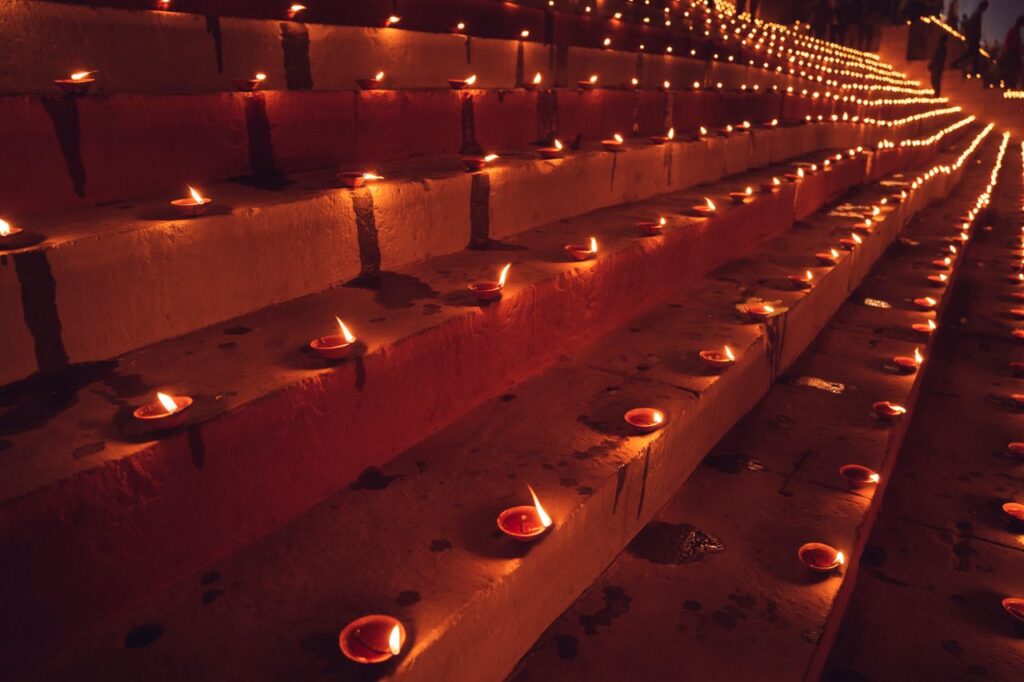 Millions of illuminated diyas lighting the ghats of Varanasi during Dev Deepawali celebrations Illuminated clay lamps arranged in rows on steps during a night festival.